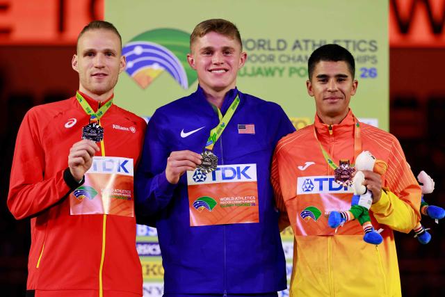 Silver medallist Belgium's Eliott Crestan (L), gold medallist USA's Cooper Lutkenhaus and bronze medallist Spain's Mohamed Attaoui celebrate on the podium for the men's 800m event during the World Athletics Indoor Championships Kujawy Pomorze 2026 in Torun, Poland on March 22, 2026. (Photo by Wojtek RADWANSKI / AFP)