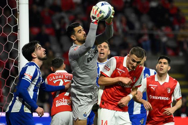 FC Porto's Portuguese goalkeeper #99 Diogo Costa catches the ball past Sporting Braga's Swedish defender #14 Gustaf Lagerbielke during the Portuguese League football match between SC Braga and FC Porto at Municipal stadium of Braga on March 22, 2026. (Photo by Miguel RIOPA / AFP)