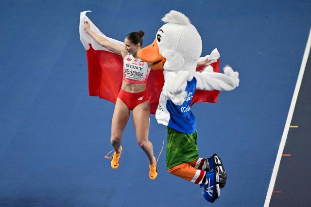 Poland's Pia Skrzyszowska celebrates placing third with mascot goosie after the women's final 60 metres hurdles event during the World Athletics Indoor Championships Kujawy Pomorze 2026 in Torun, Poland on March 22, 2026. (Photo by Andrej ISAKOVIC / AFP)