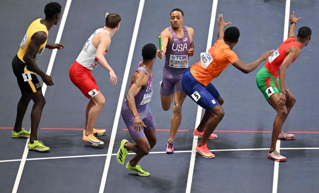 USA's Justin Robinson and USA's Chris Robinson exchange the baton in the men's final 4x400 metres relay event during the World Athletics Indoor Championships Kujawy Pomorze 2026 in Torun, Poland on March 22, 2026. (Photo by Andrej ISAKOVIC / AFP)