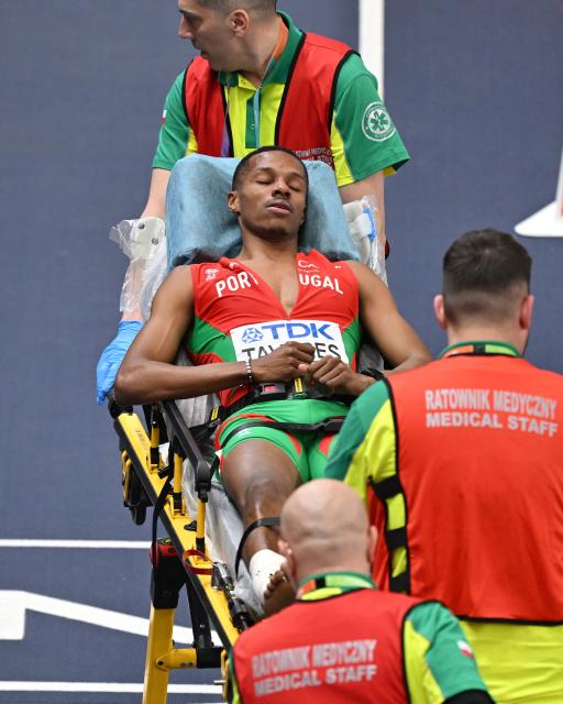 Portugal's Ericsson Tavares reacts as he is taken away on a stretcher by medical staff after an injury in the men's final 4x400 metres relay event during the World Athletics Indoor Championships Kujawy Pomorze 2026 in Torun, Poland on March 22, 2026. (Photo by Andrej ISAKOVIC / AFP)