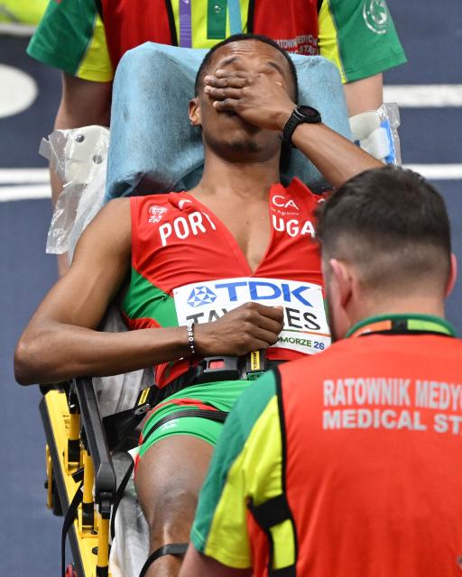 Portugal's Ericsson Tavares reacts as he is taken away on a stretcher by medical staff after an injury in the men's final 4x400 metres relay event during the World Athletics Indoor Championships Kujawy Pomorze 2026 in Torun, Poland on March 22, 2026. (Photo by Andrej ISAKOVIC / AFP)