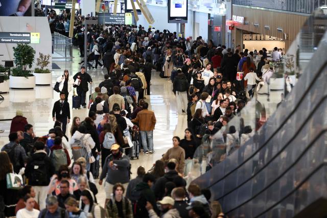 (From L) Guest, Guest, Guest, Guest, Guest, Guest, Guest, Guest, Guest, Guest and China's athlete Dai Qianqian Passengers queue to go through security at New York's LaGuardia airport on March 22, 2026. Immigration agents will be deployed in US airports beginning March 23, aiming to alleviate soaring congestion at security screenings amid a weeks-long budget standoff over President Donald Trump's mass deportation drive, officials said. Trump announced the extraordinary move in a social media post Sunday morning, sending officials racing to quickly develop a plan (Photo by CHARLY TRIBALLEAU / AFP)