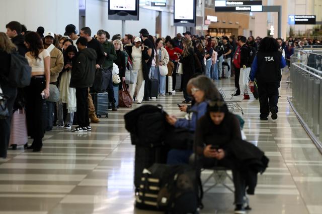 (From L) Guest, Guest, Guest, Guest, Guest, Guest, Guest, Guest, Guest, Guest and China's athlete Dai Qianqian Passengers queue to go through security at New York's LaGuardia airport on March 22, 2026. Immigration agents will be deployed in US airports beginning March 23, aiming to alleviate soaring congestion at security screenings amid a weeks-long budget standoff over President Donald Trump's mass deportation drive, officials said. Trump announced the extraordinary move in a social media post Sunday morning, sending officials racing to quickly develop a plan (Photo by CHARLY TRIBALLEAU / AFP)