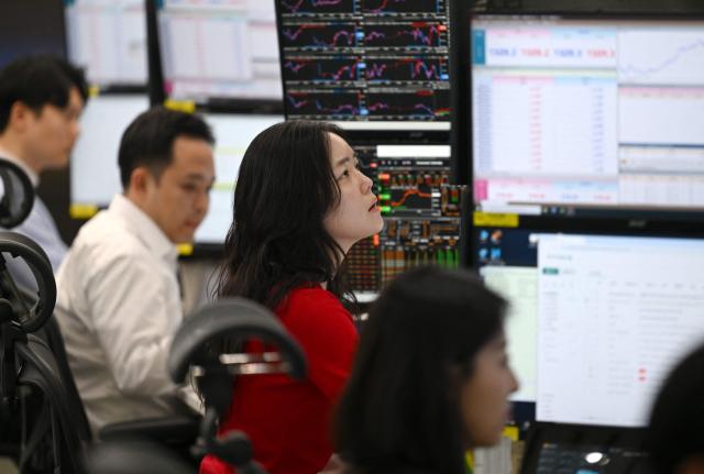Currency dealers monitor exchange rates in a foreign exchange dealing room at the Hana Bank headquarters in Seoul on March 23, 2026. South Korea's won dropped to its weakest level against the US dollar in 17 years in early trading on March 23, amid market volatility sparked by the Iran war. (Photo by Jung Yeon-je / AFP)