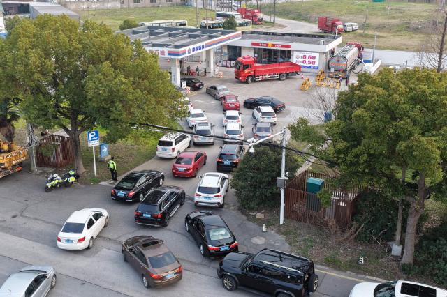 Motorists queue to fill their tanks ahead of a petrol price adjustment expected on March 23, at a petrol station in Suzhou, in China’s eastern Jiangsu province on March 22, 2026. (Photo by CN-STR / AFP) / China OUT