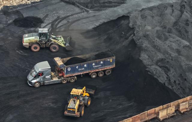 A truck is loaded with coal at a coal terminal on the Yangtze river in Nanjing, in China’s eastern Jiangsu province, on March 22, 2026. (Photo by CN-STR / AFP) / China OUT