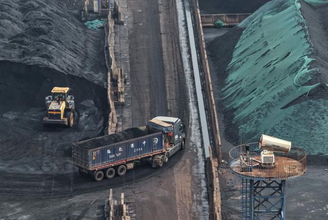 A truck carries coal at a coal terminal on the Yangtze river in Nanjing, in China’s eastern Jiangsu province, on March 22, 2026. (Photo by CN-STR / AFP) / China OUT