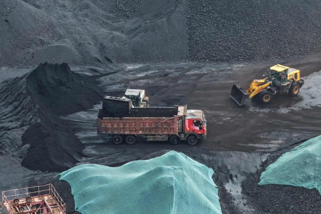 A truck is loaded with coal at a coal terminal on the Yangtze river in Nanjing, in China’s eastern Jiangsu province, on March 22, 2026. (Photo by CN-STR / AFP) / China OUT