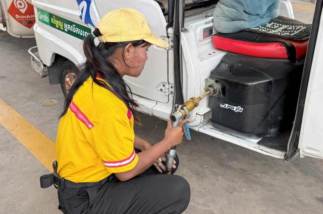 An employee pumps liquefied petroleum gas (LPG) into the vehicle of a customer at a fuel station in Phnom Penh on March 23, 2026. A major energy supplier in Cambodia has said it will halt sales of liquefied petroleum gas from the start of next month due to supply disruptions resulting from the Middle East war. (Photo by TANG CHHIN Sothy / AFP)