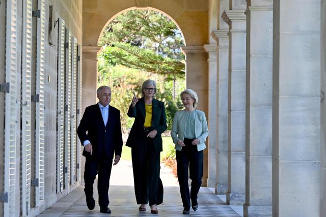 European Commission President Ursula von der Leyen (R) walks with Australia's Governor-General Sam Mostyn (C) and Australia's Trade Minister Don Farrell (L) along the colonnaded verandah at Admiralty House in Sydney on March 23, 2026. (Photo by Saeed KHAN / AFP)