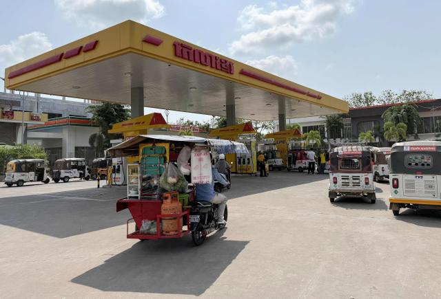 Tuk tuk vehicles queue up to refuel with liquefied petroleum gas (LPG) at a fuel station in Phnom Penh on March 23, 2026. A major energy supplier in Cambodia has said it will halt sales of liquefied petroleum gas from the start of next month due to supply disruptions resulting from the Middle East war. (Photo by TANG CHHIN Sothy / AFP)