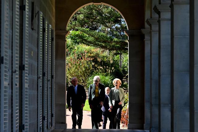 European Commission President Ursula von der Leyen (R) walks with Australia's Governor-General Sam Mostyn (C) and Australia's Trade Minister Don Farrell (L) along the colonnaded verandah at Admiralty House in Sydney on March 23, 2026. (Photo by Saeed KHAN / AFP)