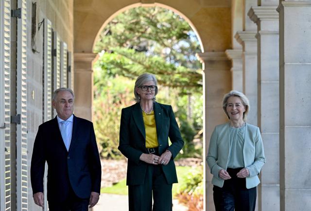 European Commission President Ursula von der Leyen (R) walks with Australia's Governor-General Sam Mostyn (C) and Australia's Trade Minister Don Farrell (L) along the colonnaded verandah at Admiralty House in Sydney on March 23, 2026. (Photo by Saeed KHAN / AFP)