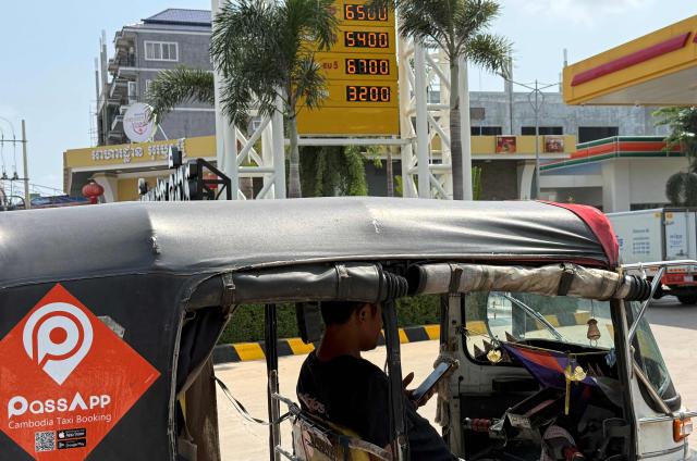 A driver waits in his tuk tuk vehicle to refuel with liquefied petroleum gas (LPG) at a fuel station in Phnom Penh on March 23, 2026. A major energy supplier in Cambodia has said it will halt sales of liquefied petroleum gas from the start of next month due to supply disruptions resulting from the Middle East war. (Photo by TANG CHHIN Sothy / AFP)