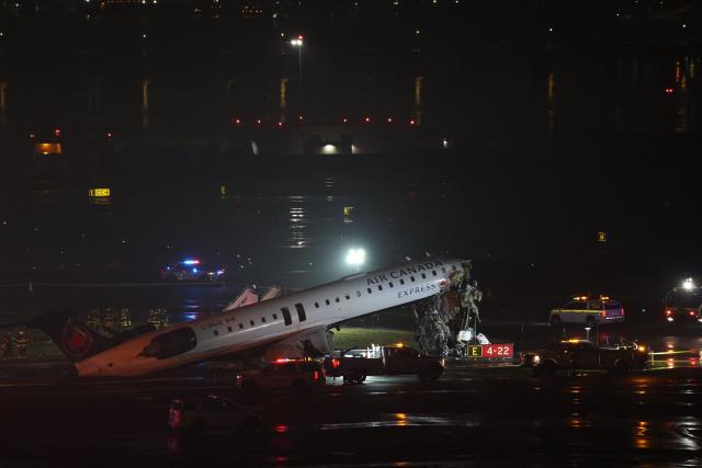 Emergency personnel respond to an Air Canada Express CRJ-900 that is sitting on the runway after colliding with a Port Authority fire truck at LaGuardia Airport in New York, on March 23, 2026. Air Canada Express flight AC8646 originated from Montreal and collided with the fire truck during landing. (Photo by ANGELA WEISS / AFP)
