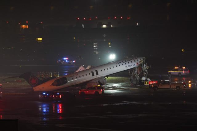 Emergency personnel respond to an Air Canada Express CRJ-900 that is sitting on the runway after colliding with a Port Authority fire truck at LaGuardia Airport in New York, on March 23, 2026. Air Canada Express flight AC8646 originated from Montreal and collided with the fire truck during landing. (Photo by ANGELA WEISS / AFP)