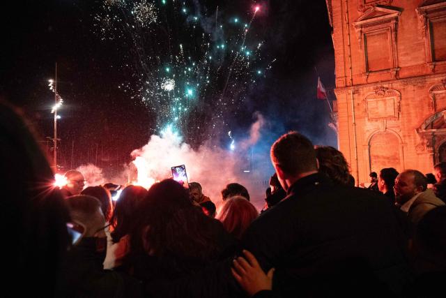 This photograph shows a firework exploding next to the city hall as Marseille's incumbent mayor and broad left-wing coalition Printemps Marseillais candidate for re-election Benoit Payan celebrates with supporters after winning the second round of France's 2026 municipal elections in a bar in Marseille, southern France on March 22, 2026. (Photo by Elodie CLEMENT / AFP)