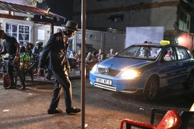 Sapeurs danse in a street near their meeting place in Brazzaville on March 22, 2026. Sapology, or Sape (Société des Ambianceurs et des Personnes Élégantes), is a fashion counter-culture that originated in the Congo (Brazzaville and Kinshasa), characterised by the wearing of colourful and eccentric designer suits. A true philosophy, it celebrates elegance, dandyism, an appreciation for colour harmony and the joy of living. (Photo by Daniel BELOUMOU OLOMO / AFP)