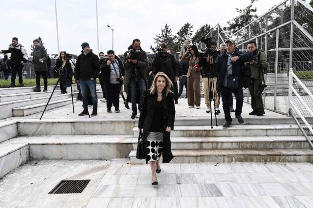 Tempi 2023 Victims' Association president Maria Karystianou (C) arrives at the "Gaipolis" conference venue at the University campus in Larissa to attend the opening hearing of the trial over the deadly Tempi train crash, which killed 57 people in the worst rail accident in Greek history, on March 23, 2026. The case is moving to trial more than three years after the fatal night of February 28, 2023 when two trains collided head-on, to investigate the responsibility for the worst railroad accident in Greece's history. (Photo by Sakis Mitrolidis / AFP)