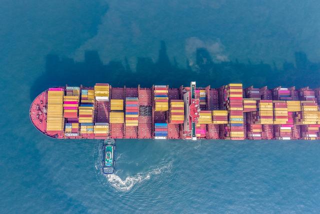 A cargo ship is moved to a berth at the container terminal at the port in Qingdao, in China’s eastern Shandong province on March 23, 2026. (Photo by CN-STR / AFP) / China OUT