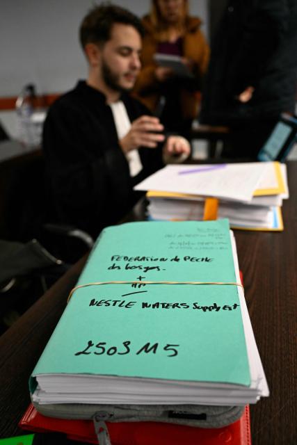 Lawyer Amine Ouajjid, representing consumer association Que Choisir-Ensemble, gets ready for the opening hearing of the Nestle Waters trial over the maintenance of four illegal waste dumps in the Vosges department at the judicial complex in Nancy on March 23, 2026. (Photo by Jean-Christophe VERHAEGEN / AFP)