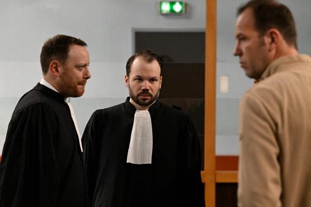 Nestle Waters lawyers Maël Bertho (L) and Flavian Ruda (C) speak together ahead of the opening hearing of the Nestle Waters trial over the maintenance of four illegal waste dumps in the Vosges department at the judicial complex in Nancy on March 23, 2026. (Photo by Jean-Christophe VERHAEGEN / AFP)