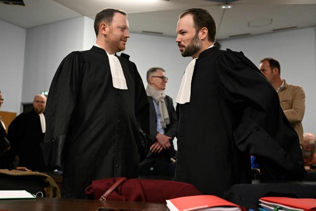 Nestle Waters lawyers Maël Bertho (L) and Flavian Ruda (R) speak together ahead of the opening hearing of the Nestle Waters trial over the maintenance of four illegal waste dumps in the Vosges department at the judicial complex in Nancy on March 23, 2026. (Photo by Jean-Christophe VERHAEGEN / AFP)