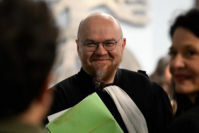 Lawyer Francois Zind, representing environmental associations France Nature Environnement, Lorraine Nature Environnement, Vosges Nature Environnement and Robins des Bois is pictured ahead of the opening hearing of the Nestle Waters trial over the maintenance of four illegal waste dumps in the Vosges department at the judicial complex in Nancy on March 23, 2026. (Photo by Jean-Christophe VERHAEGEN / AFP)