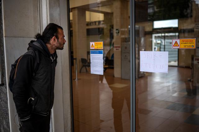 A man stands outside of central train station in Athens during a 24-hour general strike on March 23, 2026. A long-awaited trial opened on March 23, 2026 over Greece's worst train tragedy that killed 57 people in 2023, leaving the entire country in shock, an AFP reporter said. Thirty-six people face charges and over 350 witnesses are due to be heard at the trial in the central city of Larissa, near where a freight train and a passenger train collided on February 28, 2023. (Photo by Angelos TZORTZINIS / AFP)