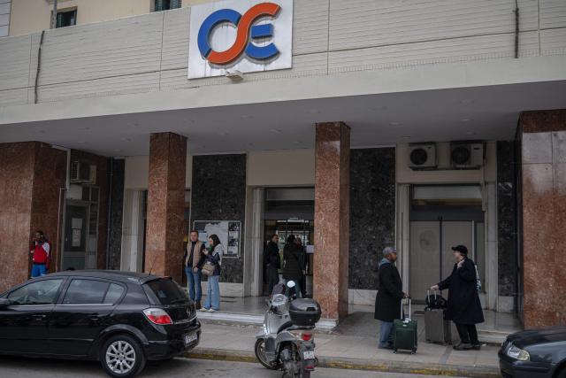 People stand outside the central train station in Athens during a 24-hour general strike on March 23, 2026. A long-awaited trial opened on March 23, 2026 over Greece's worst train tragedy that killed 57 people in 2023, leaving the entire country in shock, an AFP reporter said. Thirty-six people face charges and over 350 witnesses are due to be heard at the trial in the central city of Larissa, near where a freight train and a passenger train collided on February 28, 2023. (Photo by Angelos TZORTZINIS / AFP)