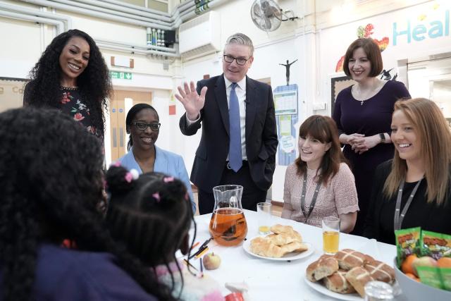 Britain's Prime Minister Keir Starmer (C) and Britain's Education Secretary Bridget Phillipson (top R) meet with staff as they pay a visit to St Paul's Church of England Primary School in southeast London on March 23, 2026, to announce further cost-of-living support for parents through an expansion of the government's school-based nurseries. (Photo by Stefan Rousseau / POOL / AFP)