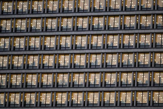 Corporate employees are seen at their desks in an office building in downtown Tokyo's Chiyoda area on March 23, 2026. (Photo by ANDREW CABALLERO-REYNOLDS / AFP)