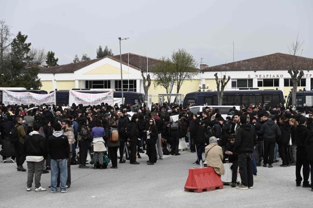 People gather outside the "Gaipolis" conference venue at the University campus in Larissa as the trial opens over the deadly Tempi train crash, which killed 57 people in the worst rail accident in Greek history, on March 23, 2026. The case is moving to trial more than three years after the fatal night of February 28, 2023 when two trains collided head-on, to investigate the responsibility for the worst railroad accident in Greece's history. (Photo by Sakis Mitrolidis / AFP)