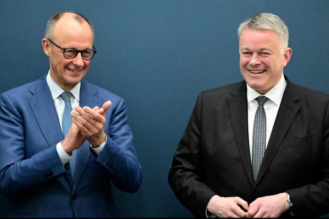 German Chancellor Friedrich Merz (L) applauds Gordon Schnieder, the conservative CDU party's top candidate for state elections in the southwestern state of Rhineland-Palatinate, on March 23, 2026, one day after the vote, at the CDU's headquarters in Berlin. German Chancellor Friedrich Merz's conservatives ousted the centre-left Social Democratic Party in the closely watched state election in which the far right also made big gains, according to exit polls. (Photo by Tobias SCHWARZ / AFP)