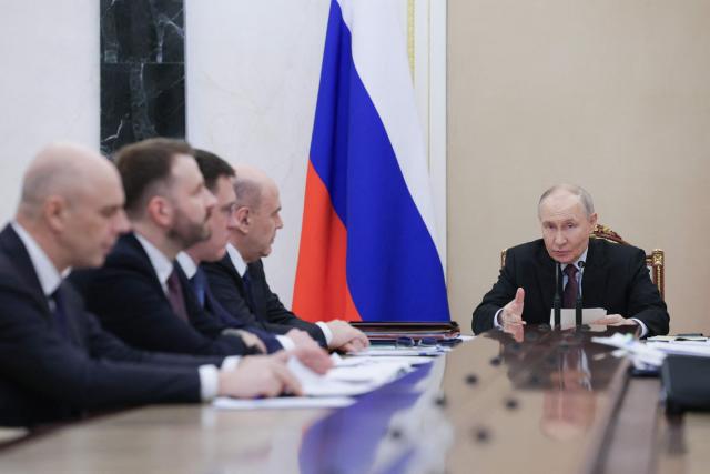 In this pool photograph distributed by the Russian state agency Sputnik, Russia's President Vladimir Putin (R) chairs a meeting on economic issues in Moscow on March 23, 2026. (Photo by Gavriil Grigorov / POOL / AFP)