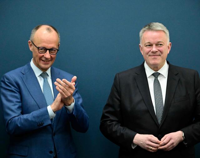 German Chancellor Friedrich Merz (L) applauds Gordon Schnieder, the conservative CDU party's top candidate for state elections in the southwestern state of Rhineland-Palatinate, on March 23, 2026, one day after the vote, at the CDU's headquarters in Berlin. German Chancellor Friedrich Merz's conservatives ousted the centre-left Social Democratic Party in the closely watched state election in which the far right also made big gains, according to exit polls. (Photo by Tobias SCHWARZ / AFP)