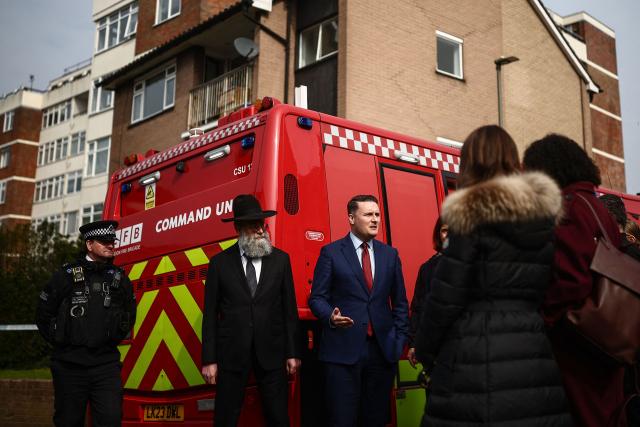 Britain's Health Secretary Wes Streeting (C) meets with members of the local community in the Golders Green neighbourhood of north London on March 23, 2026, after volunteer ambulances run by a Jewish organisation were set on fire overnight. Britain's Prime Minister Keir Starmer on March 23 condemned "a deeply shocking antisemitic arson attack" on volunteer ambulances run by a Jewish organisation in London. (Photo by Henry Nicholls / AFP)