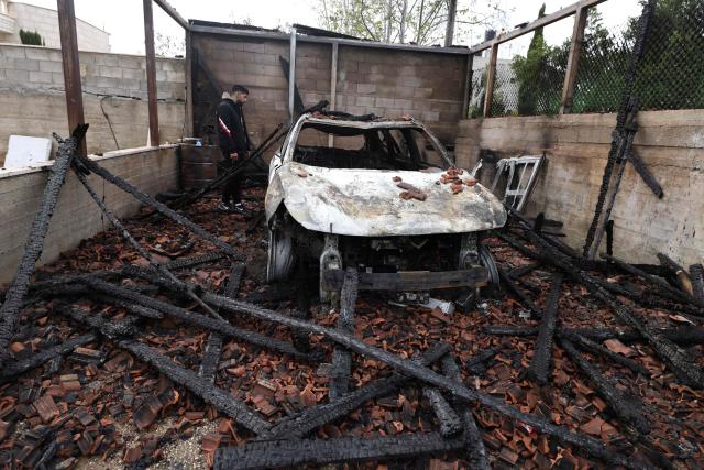 A Palestinian man inspects a burnt out vehicle following a reported attack by Israeli settlers in the village of Deir al-Hatab, east of the city of Nablus, in the Israeli-occupied West Bank on March 23, 2026. Palestinian residents said on March 22, 2026, that Israeli settlers torched buildings and cars in attacks on several villages in the occupied West Bank, with Israel's army condemning "violence of any kind" after the fact.  Violence in the Palestinian West Bank, which Israel has occupied since 1967, has soared since the Hamas attack on Israel triggered the Gaza war in October 2023. (Photo by JAAFAR ASHTIYEH / AFP)