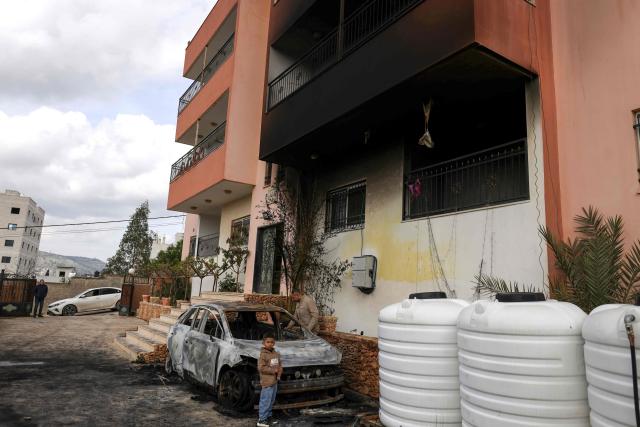 A Palestinian child stands outside a destroyed car and burnt out home following a reported attack by Israeli settlers in the village of Deir al-Hatab, east of the city of Nablus, in the Israeli-occupied West Bank on March 23, 2026. Palestinian residents said on March 22, 2026, that Israeli settlers torched buildings and cars in attacks on several villages in the occupied West Bank, with Israel's army condemning "violence of any kind" after the fact.  Violence in the Palestinian West Bank, which Israel has occupied since 1967, has soared since the Hamas attack on Israel triggered the Gaza war in October 2023. (Photo by JAAFAR ASHTIYEH / AFP)