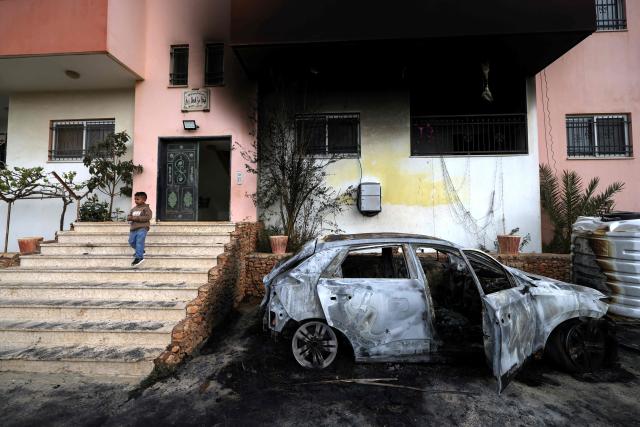TOPSHOT - A Palestinian child stands outside a destroyed car and burnt out home following a reported attack by Israeli settlers in the village of Deir al-Hatab, east of the city of Nablus, in the Israeli-occupied West Bank on March 23, 2026. Palestinian residents said on March 22, 2026, that Israeli settlers torched buildings and cars in attacks on several villages in the occupied West Bank, with Israel's army condemning "violence of any kind" after the fact.  Violence in the Palestinian West Bank, which Israel has occupied since 1967, has soared since the Hamas attack on Israel triggered the Gaza war in October 2023. (Photo by JAAFAR ASHTIYEH / AFP)