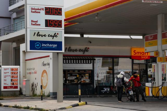 A gas station attendant refuels a motorcycle in Athens on March 23, 2026. Greek Prime Minister Kyriakos Mitsotakis on March 23, 2026 announced a raft of additional measures to mitigate the energy cost of the Middle East war. (Photo by Aris MESSINIS / AFP)