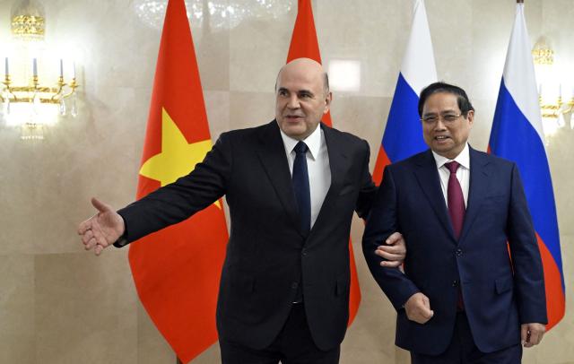 In this pool photograph distributed by the Russian state agency Sputnik, Russia's Prime Minister Mikhail Mishustin (L) greets Vietnamese Prime Minister Pham Minh Chinh ahead of a meeting in Moscow on March 23, 2026. (Photo by Alexander Miridonov / POOL / AFP)