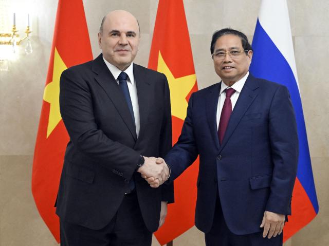 In this pool photograph distributed by the Russian state agency Sputnik, Russia's Prime Minister Mikhail Mishustin (L) greets Vietnamese Prime Minister Pham Minh Chinh ahead of a meeting in Moscow on March 23, 2026. (Photo by Alexander Miridonov / POOL / AFP)