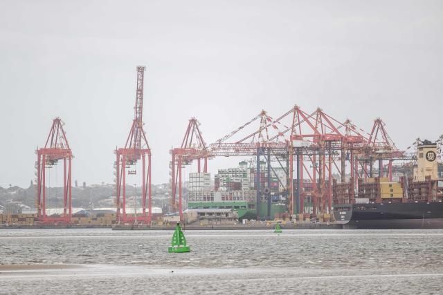iA general view of a cargo vessels docked next to cranes and containers at the Durban Harbour in Durban on March 23, 2026. (Photo by RAJESH JANTILAL / AFP)