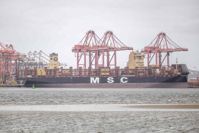A general view of a cargo vessels docked next to cranes and containers at the Durban Harbour in Durban on March 23, 2026. (Photo by RAJESH JANTILAL / AFP)