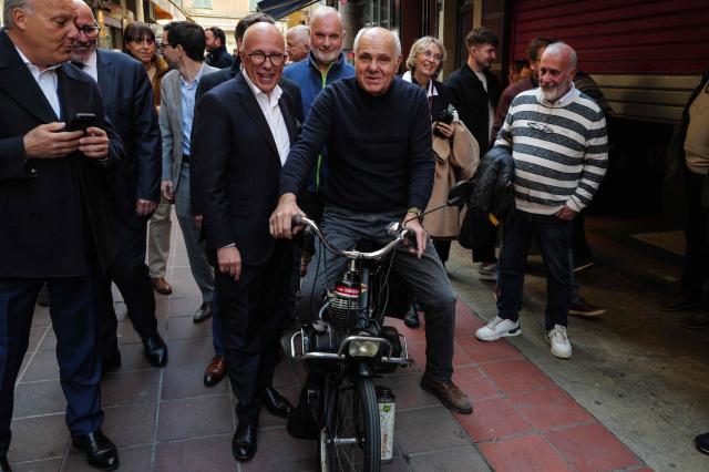 Newly elected mayor of Nice Eric Ciotti (2nd L) poses with a resident during a walk through the city streets  the day after his election, in Nice, southeastern France on March 23, 2026. (Photo by Valery HACHE / AFP)