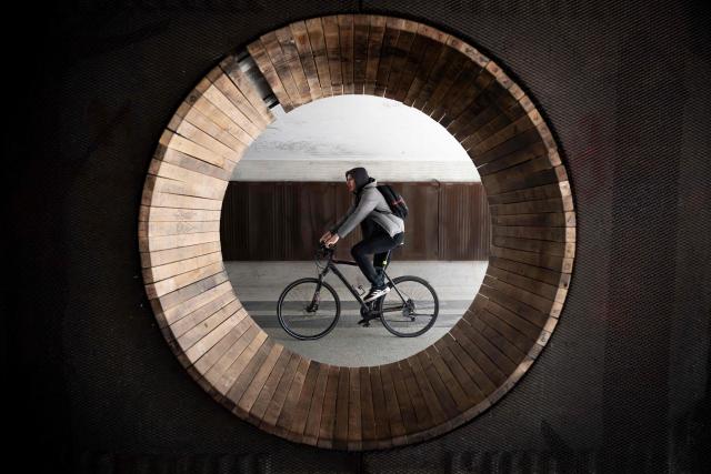 A man rides a bike in an underpass a day after the general elections in Slovenia, in Ljubljana on March 23, 2026. (Photo by Nikolay DOYCHINOV / AFP)