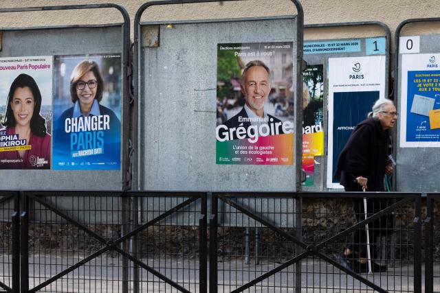An elderly person walks past billboards displaying campaign posters of mayoral candidates a day after the municipal elections in Paris on March 22, 2026. (Photo by JOEL SAGET / AFP)