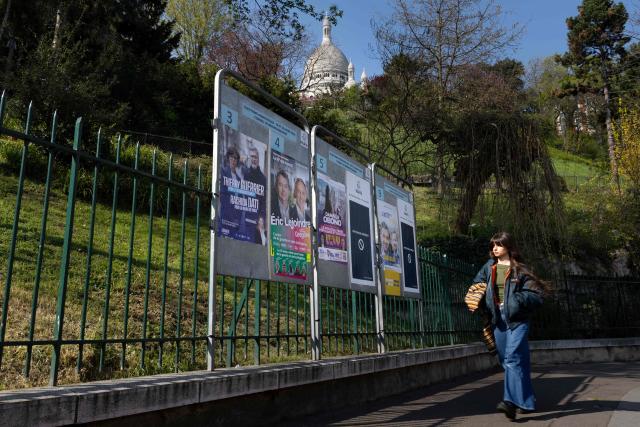 A pedestrian walks past billboards displaying campaign posters of mayoral candidates a day after the municipal elections in Paris on March 21, 2026. (Photo by JOEL SAGET / AFP)